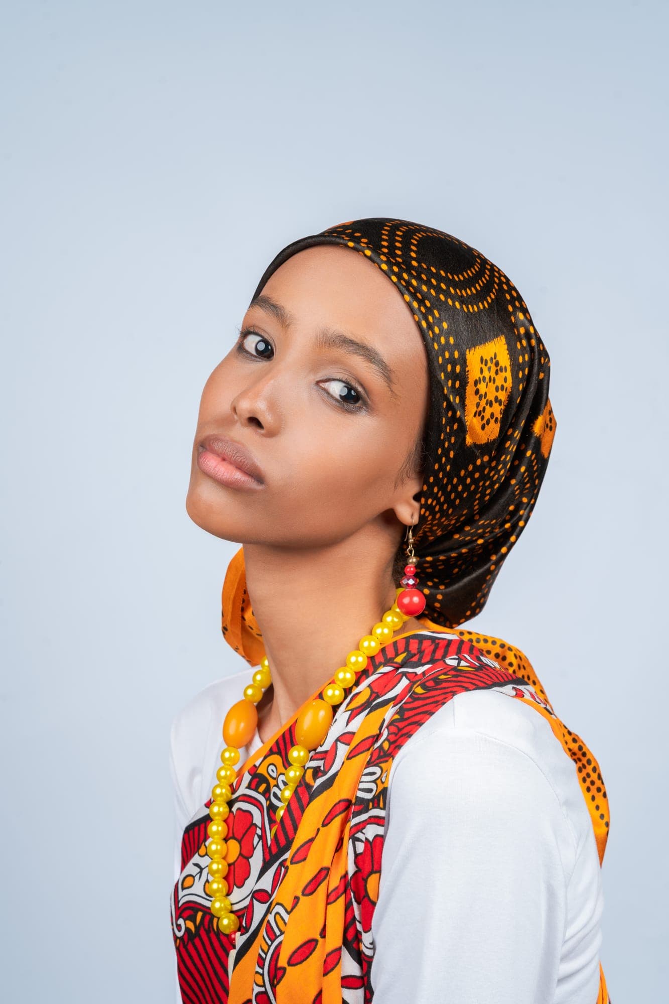 Close-up portrait of a Somali woman wearing a patterned headscarf and amber beads